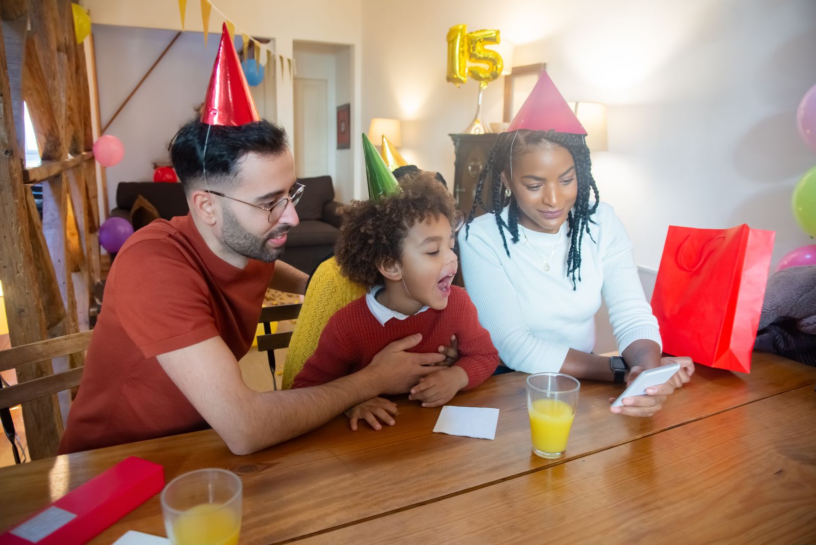 A family gathered around their table to celebrate a birthday over a video call.