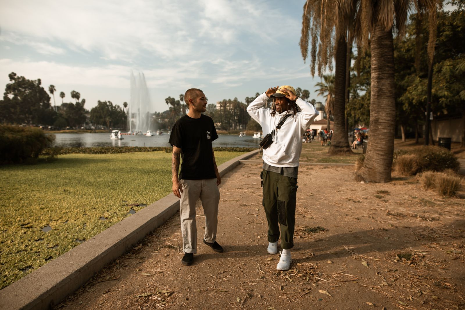 Two friends sharing a conversation on a walk through a sunlit park.